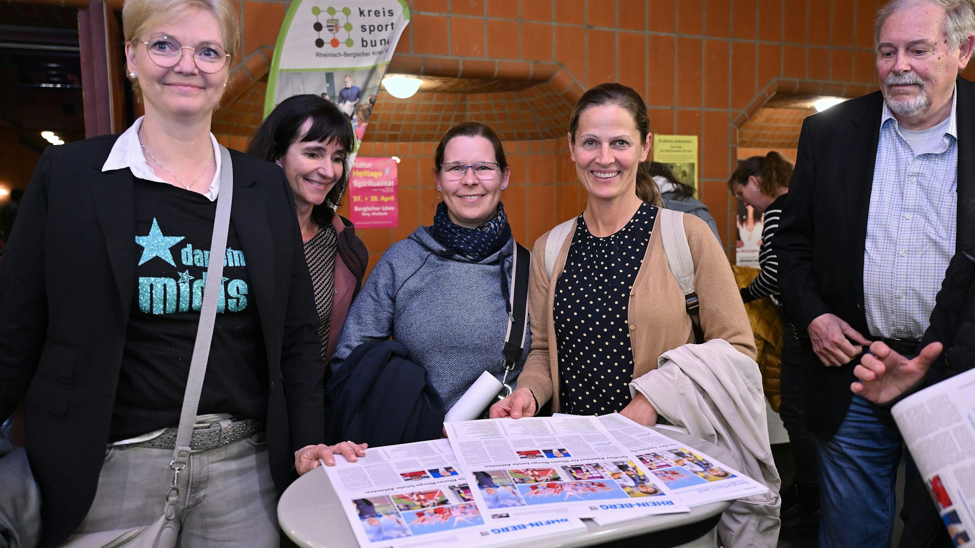 Menschen lesen bei der Sportlerehrung Rhein-Berg in der Zeitung vom folgenden Tag.