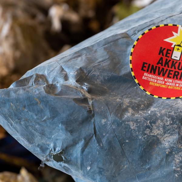 Ein Aufkleber mit der Aufschrift „Keine Akkus einwerfen“ klebt auf einem Müllsack