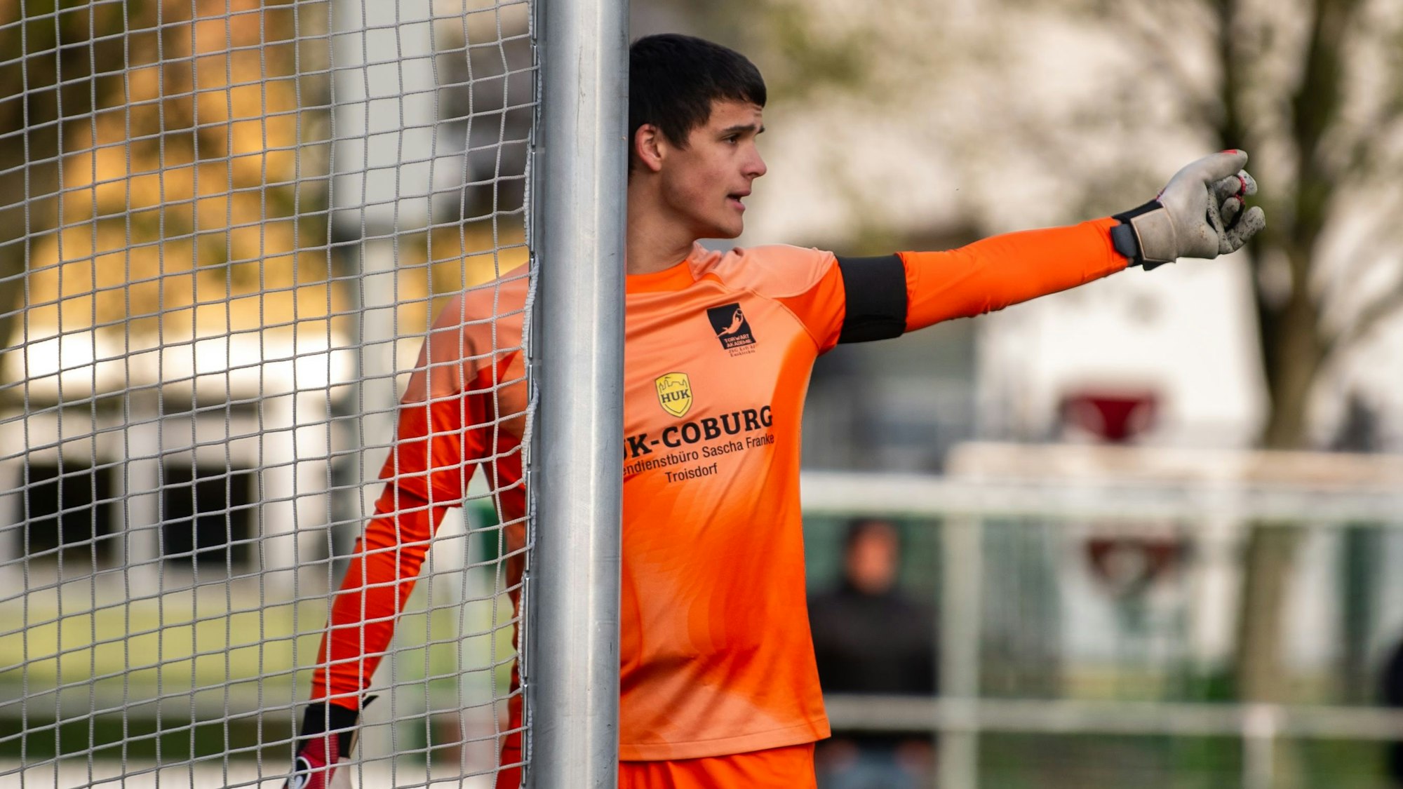 Das Bild zeigt, wie Max Vornweg am Pfosten steht und taktische Anweisungen gibt. Dafür streckt er seinen linken Arm aus.
