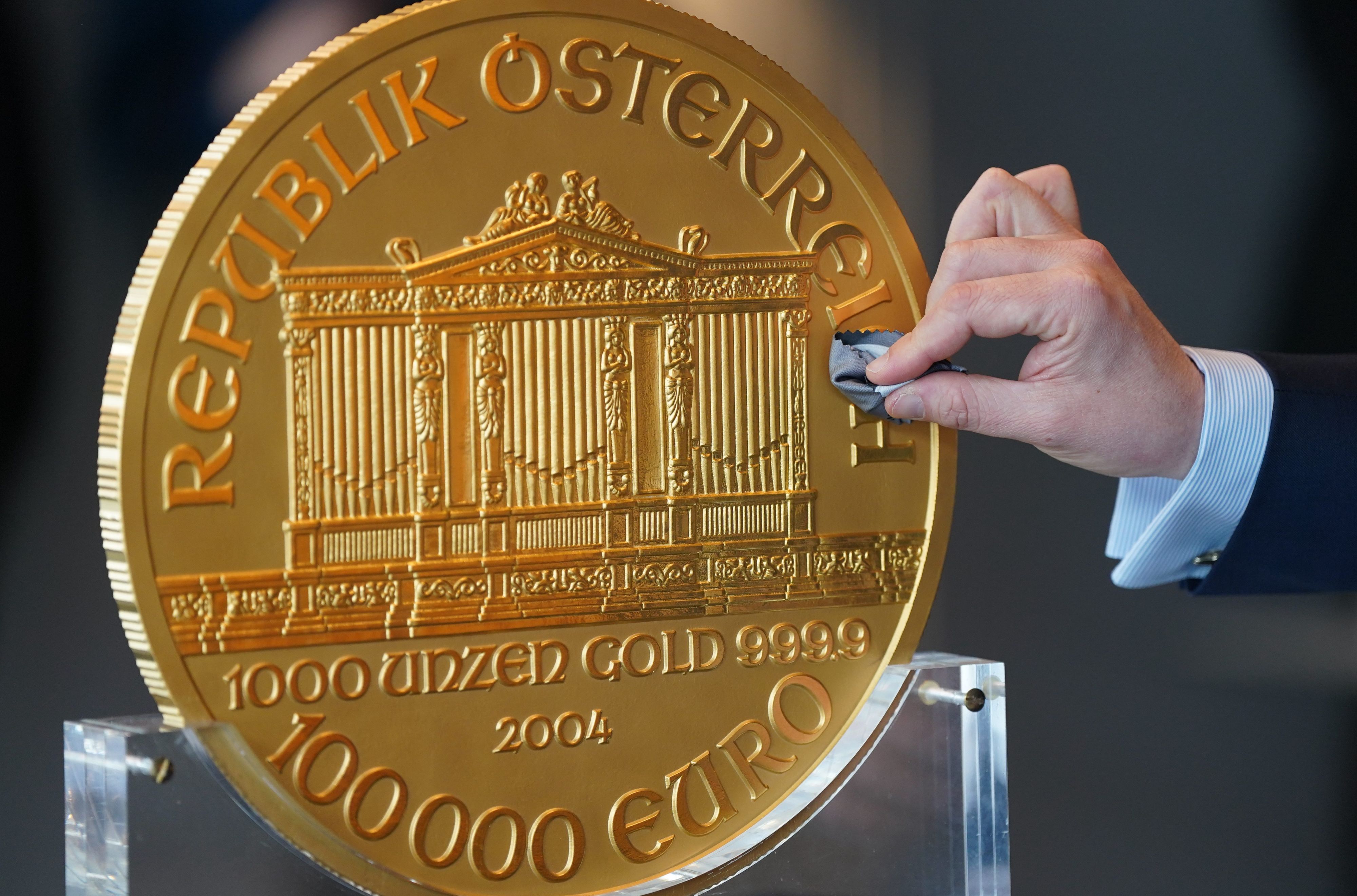 Alexander Köhne, Vertriebsleiter Pro Aurum, putzt während eines Pressetermins eine ca. 31 Kilogramm schwere und im Durchmesser etwa 37 Zentimeter große Goldmünze.