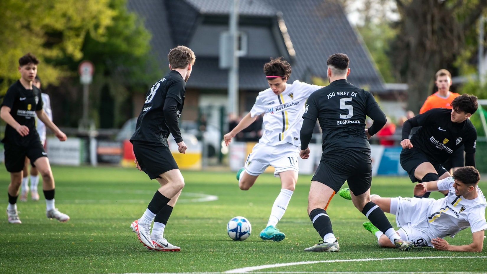 Das Bild zeigt die JSG Erft in schwarzen Trikots, wie sie mit viel Einsatz einen Torschuss versucht zu verhindern.