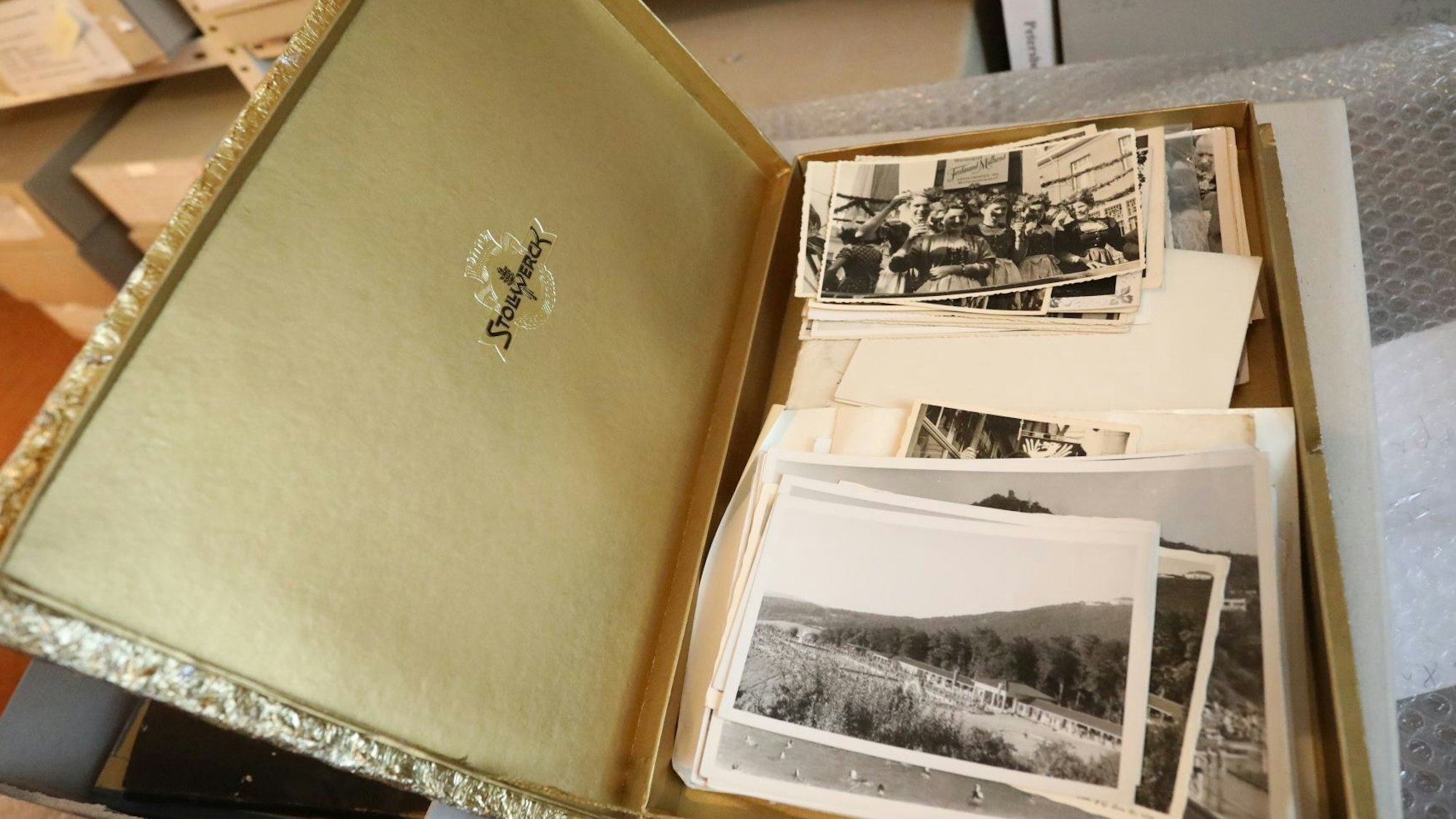 Alte Schwarz-Weiß-Aufnahmen in einem Karton, dessen Deckel geöffnet ist.