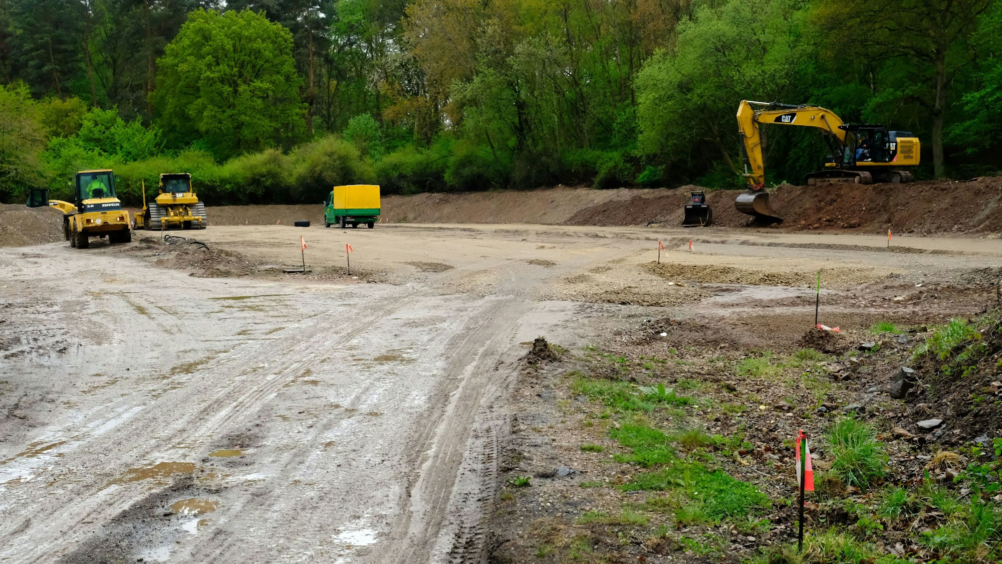 Auf einem von einem Erdwall eingefassten Bauplatz bei Mechernich sind mehrere Baumaschinen zu sehen.