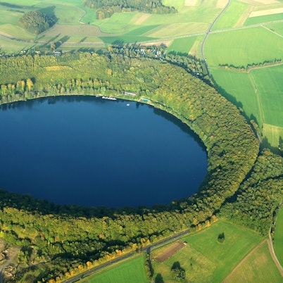 Eine Luftaufnahme zeigt das durch einen gewaltigen Vulkanausbruch entstandene Pulvermaar in der Eifel. Forscher haben 60 Kilometer entfernt von Köln Hinweise auf einen neuen Vulkan unter dem Laacher See gefunden.