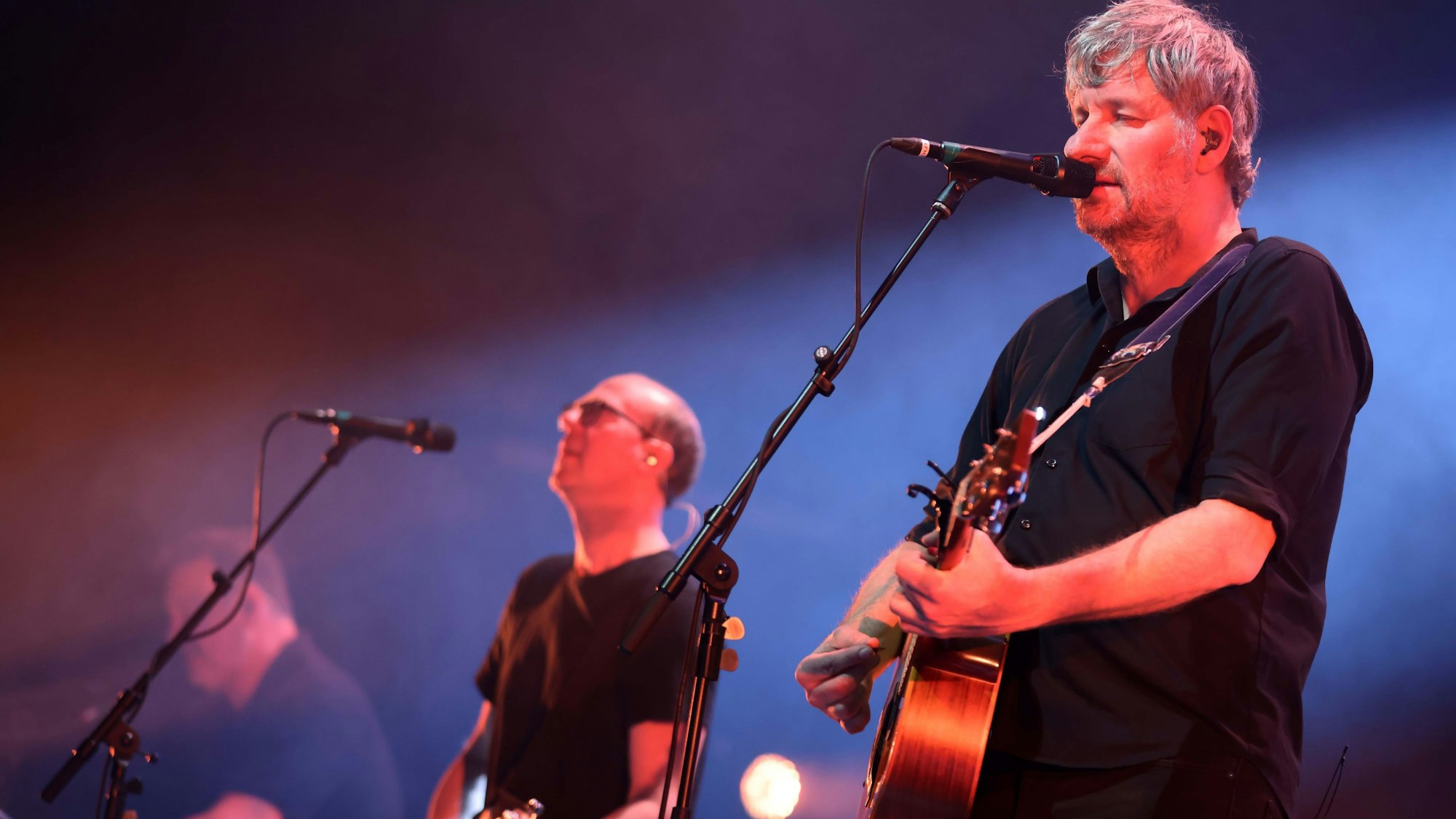 Kettcar spielen auf einer Bühne, die angeleuchet wird.