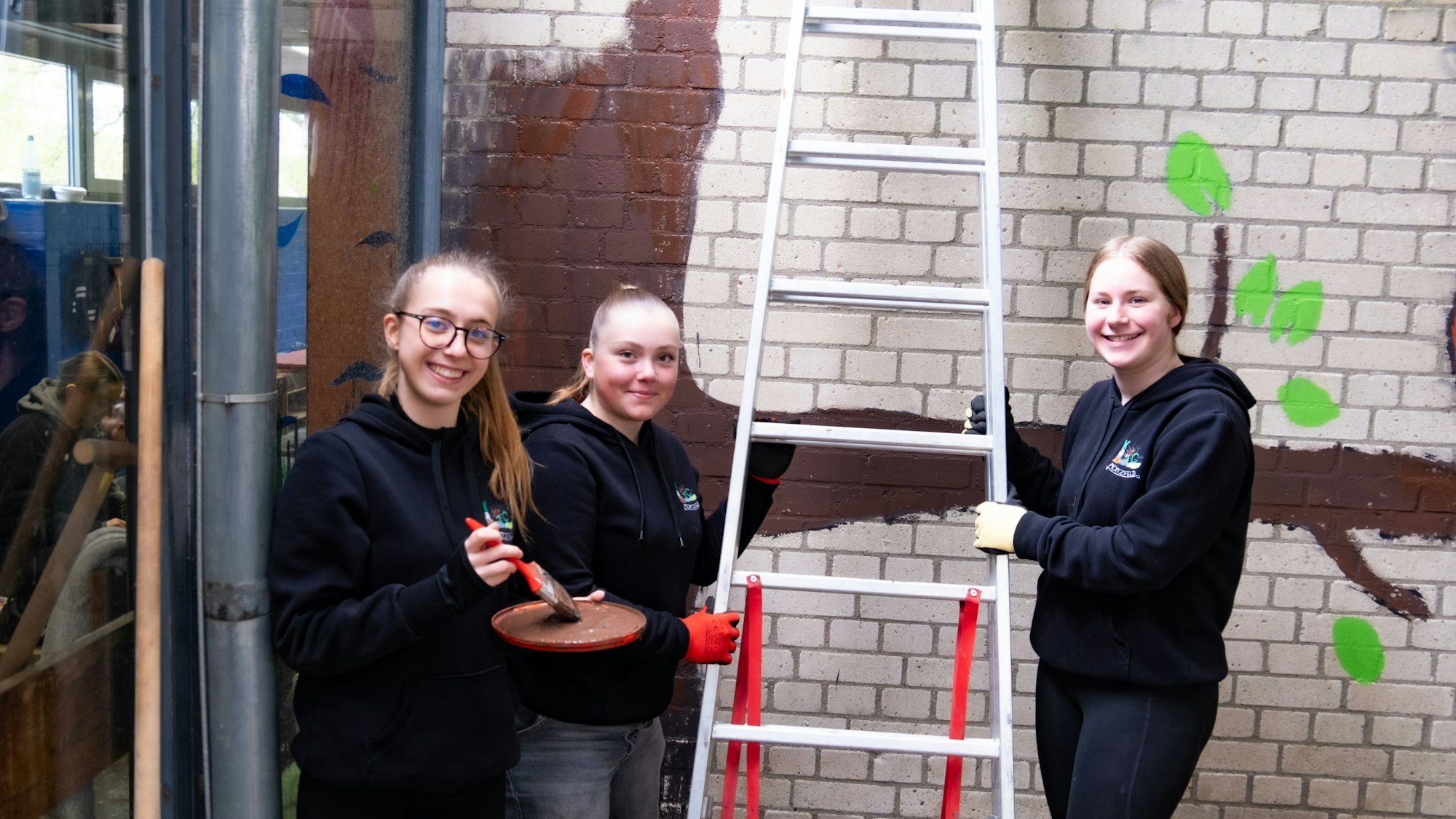Das Bild zeigt Mädchen, die in Moitzfeld die Ganztagsgrundschule anstreichen.