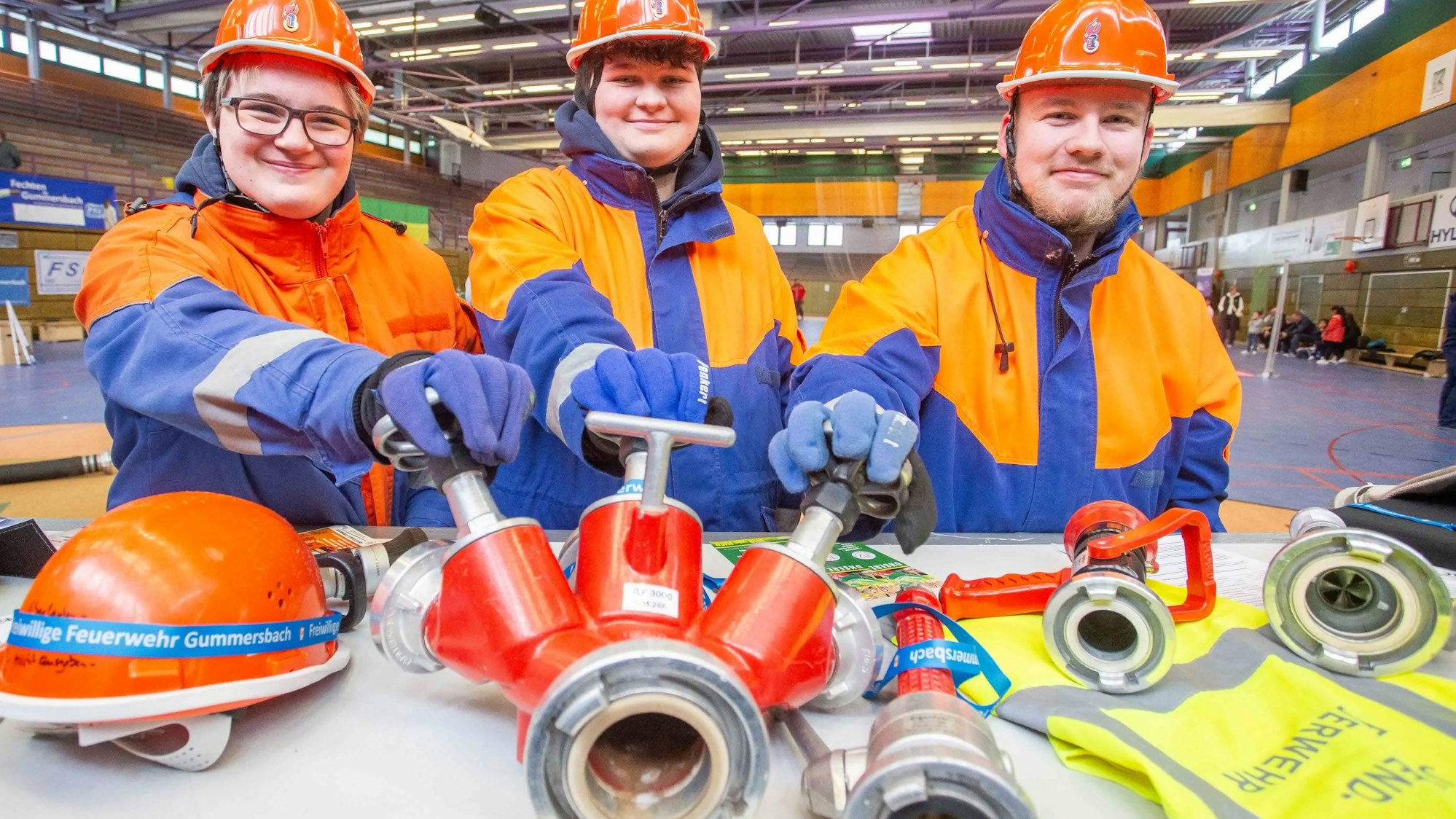Auch die Gummersbacher Jugendfeuerwehr war mit von der Partie bei der Vereinsmesse in der Kreisstadt. Lina Beumers (von links), Tamara Schroeter und Niclas Hinkel führen Ausrüstung vor. Unser Foto zeigt die Gruppe mit einem Wasserverteiler.