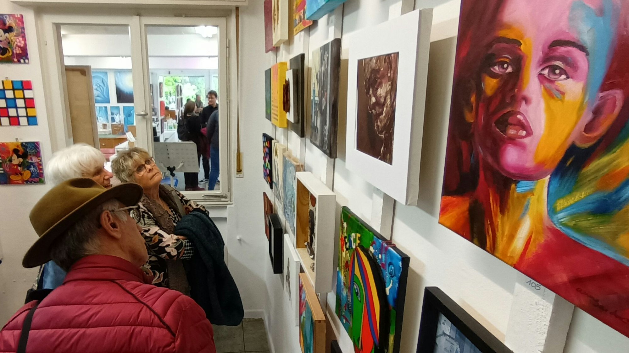 Zwei Frauen und ein Mann schauen sich Bilder an