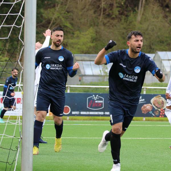 Ein Bessenicher Spieler streckt die Faust zum Jubeln in die Höhe. Ein Mitspieler tut es ihm gleich. Ein Nierfelder Spieler macht eine Verzweiflungsgeste.