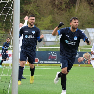 Ein Bessenicher Spieler streckt die Faust zum Jubeln in die Höhe. Ein Mitspieler tut es ihm gleich. Ein Nierfelder Spieler macht eine Verzweiflungsgeste.