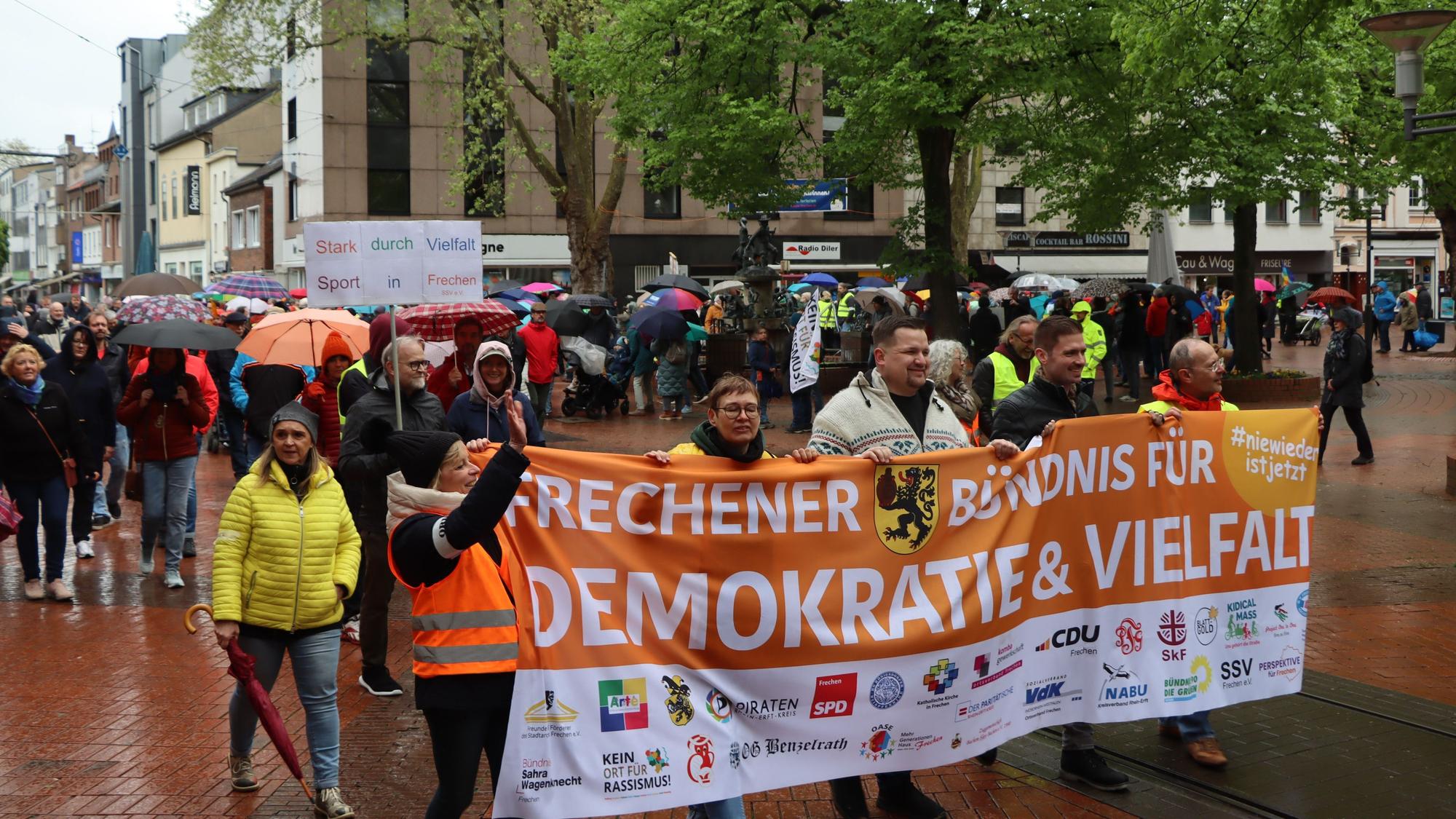 Auf dem Foto sind Teilnehmer des Demonstrationszuges für Demokratie und Vielfalt in der Frechener Innenstadt zu sehen.