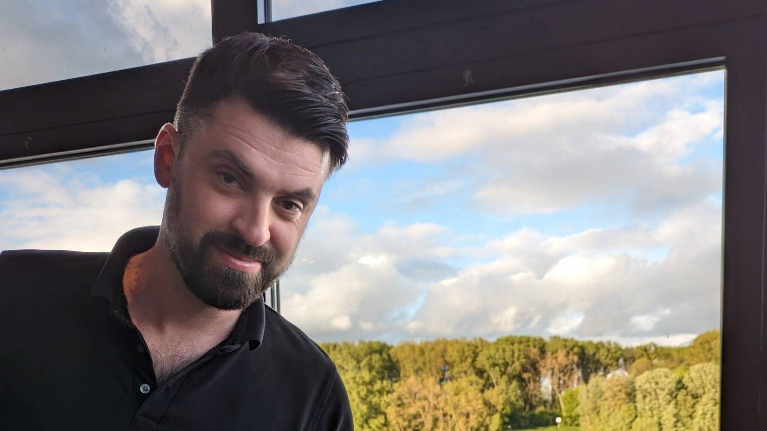 Ein Spargelgericht in der Hand eines Gastro-Mitarbeiters mit Blick durch ein Fenster auf den Rhein.