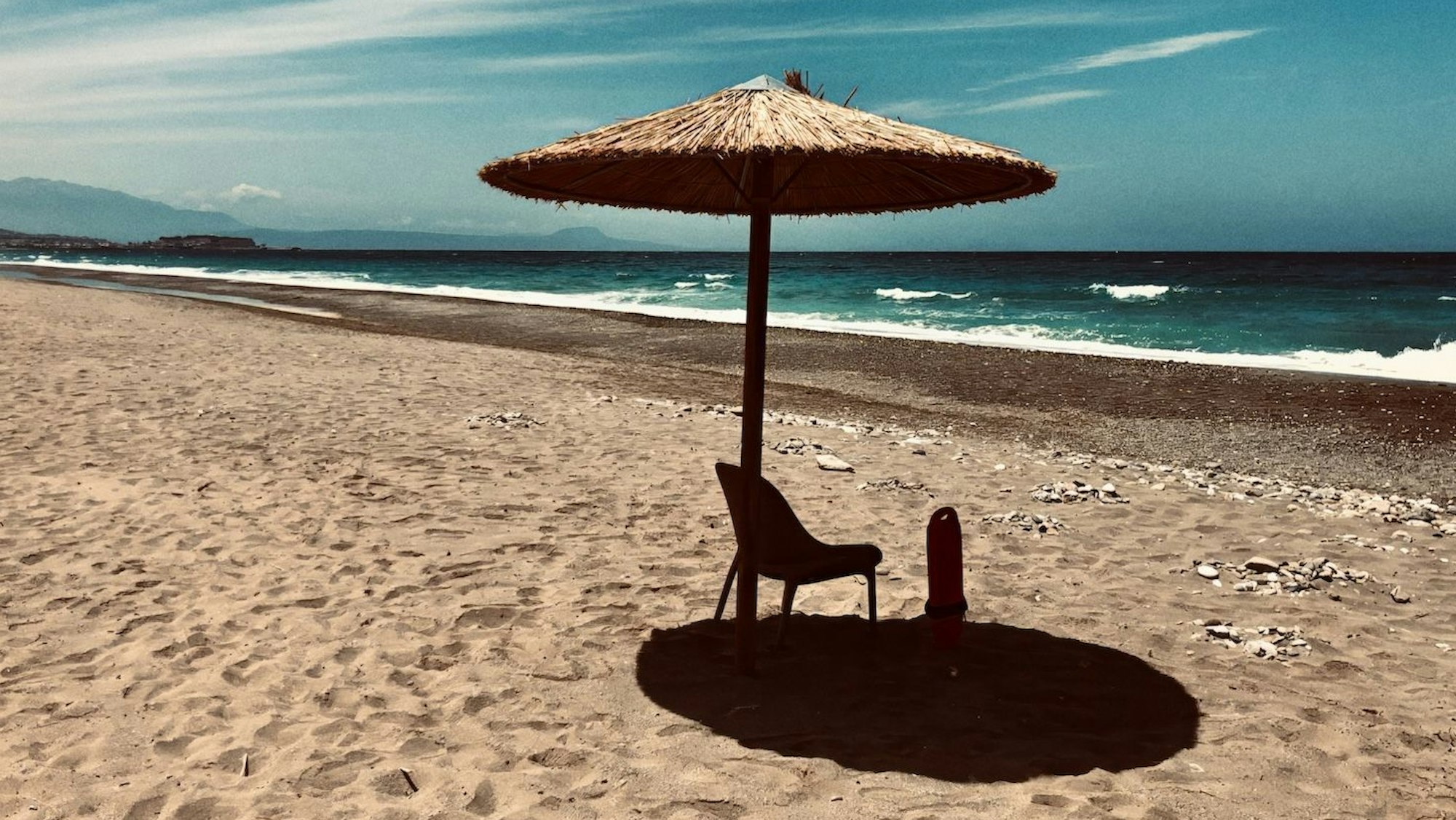 Einsamer Schirm am Strand.