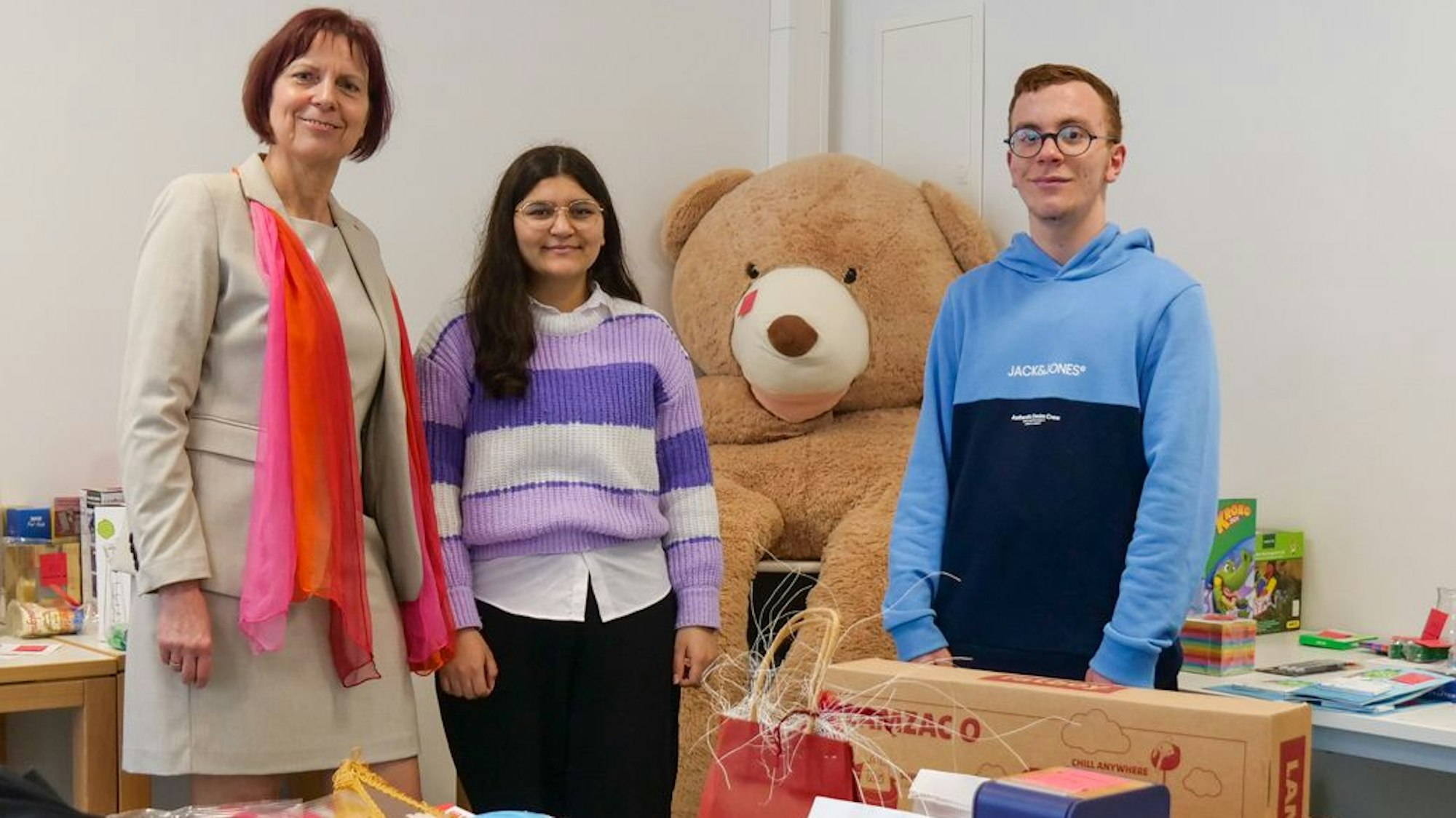 Auf dem Foto sind Schulleiterin Monika Christoffels und ihre Schüler Sarab Kiji und Mohamed Driouchi zu sehen. Sie freuten sich über die bereitgestellten Gewinne für ihre Tombola.