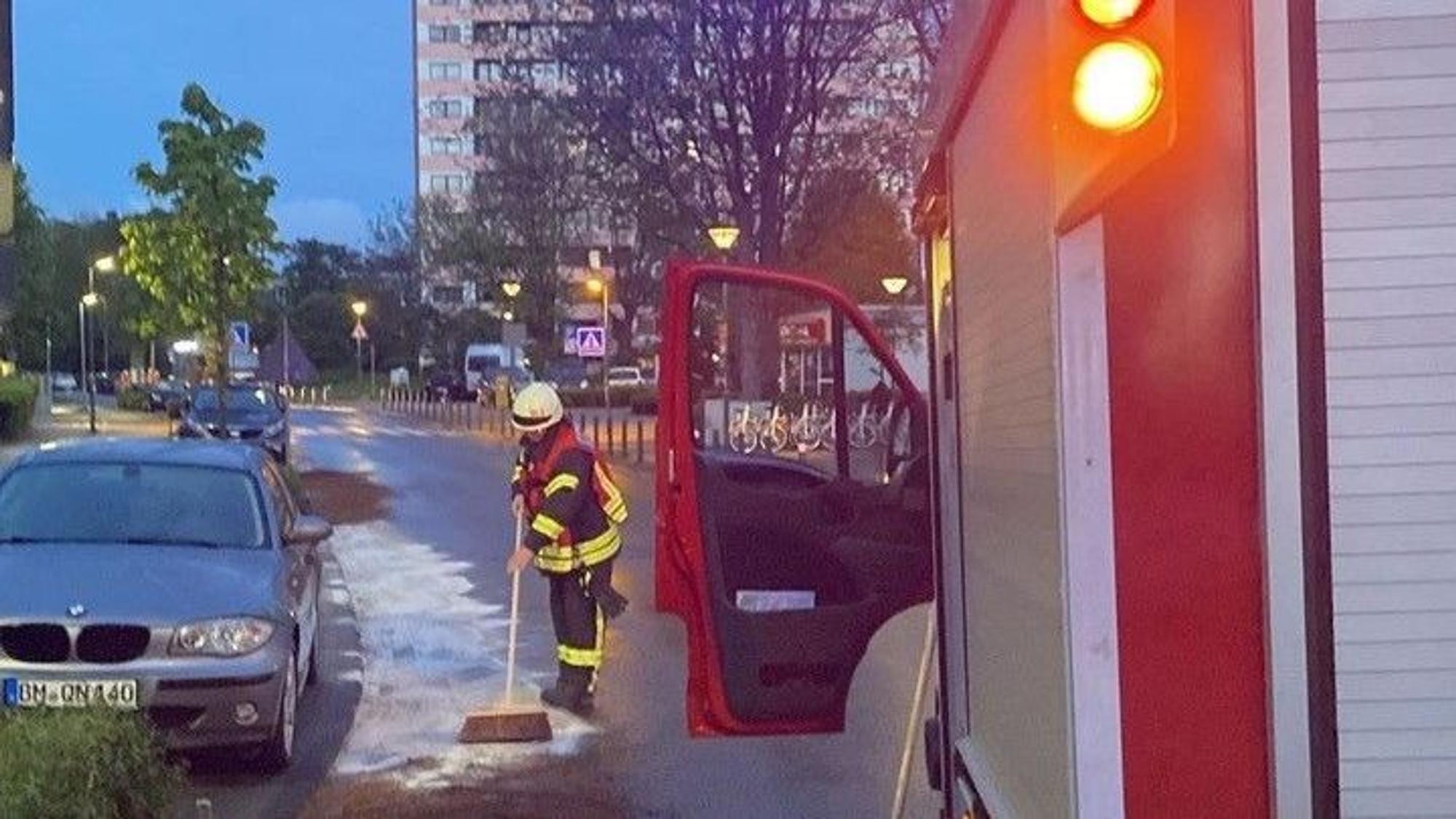 Auf dem Foto ist ein Feuerwehrmann zu sehen, der eine Ölspur bindet.