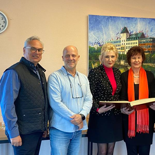 Der Vorstand der aufgelösten Innenstadtgemeinschaft Porz trägt sich ins Ehrenbuch des Stadtbezirks ein.