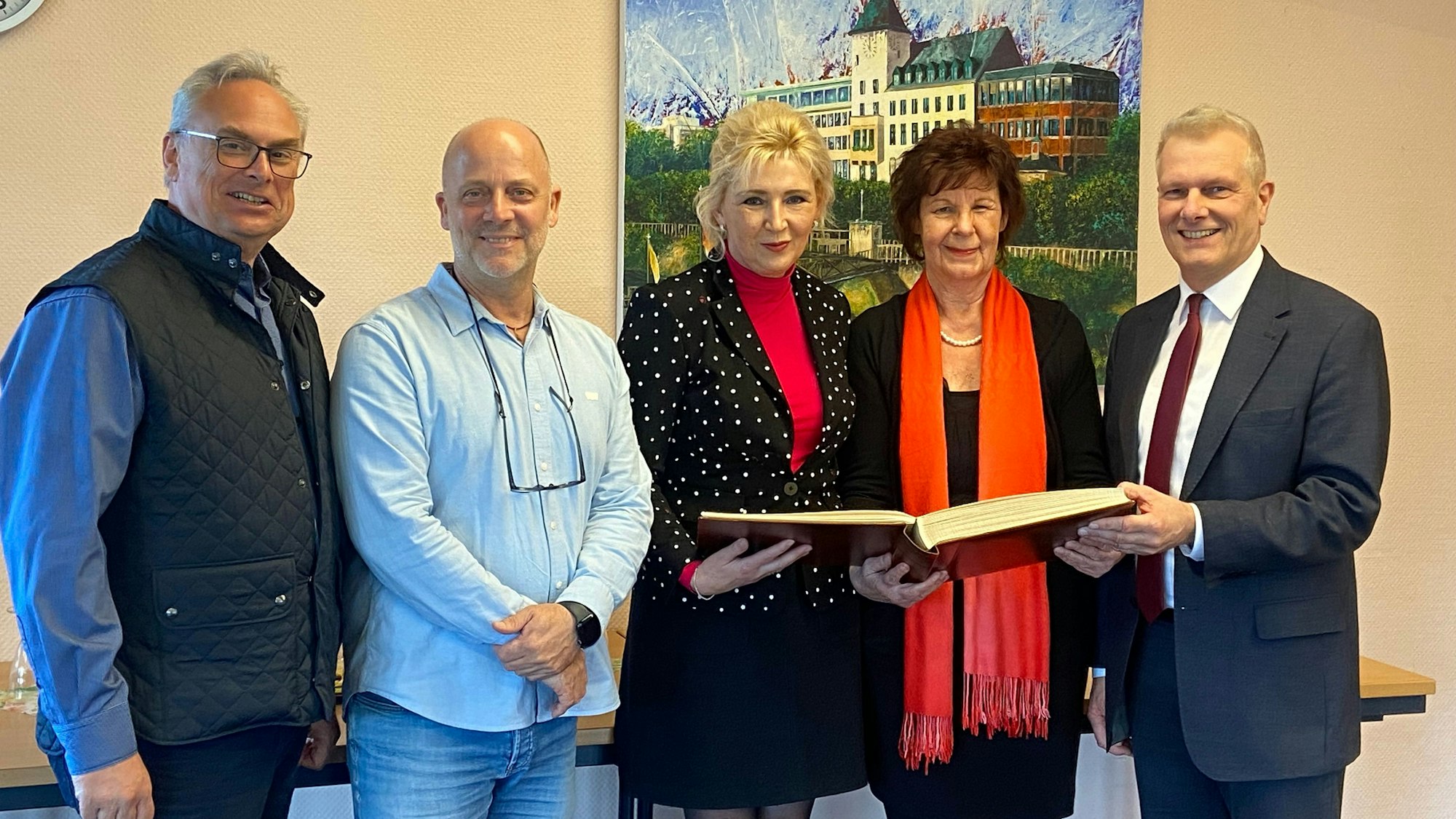 Der Vorstand der aufgelösten Innenstadtgemeinschaft Porz trägt sich ins Ehrenbuch des Stadtbezirks ein.