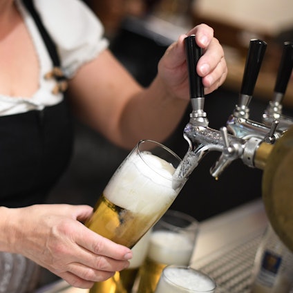 Eine Bedienung zapft Bier in einem Wirtshaus. Die Weltbierproduktion wird im laufenden Jahr voraussichtlich sinken.