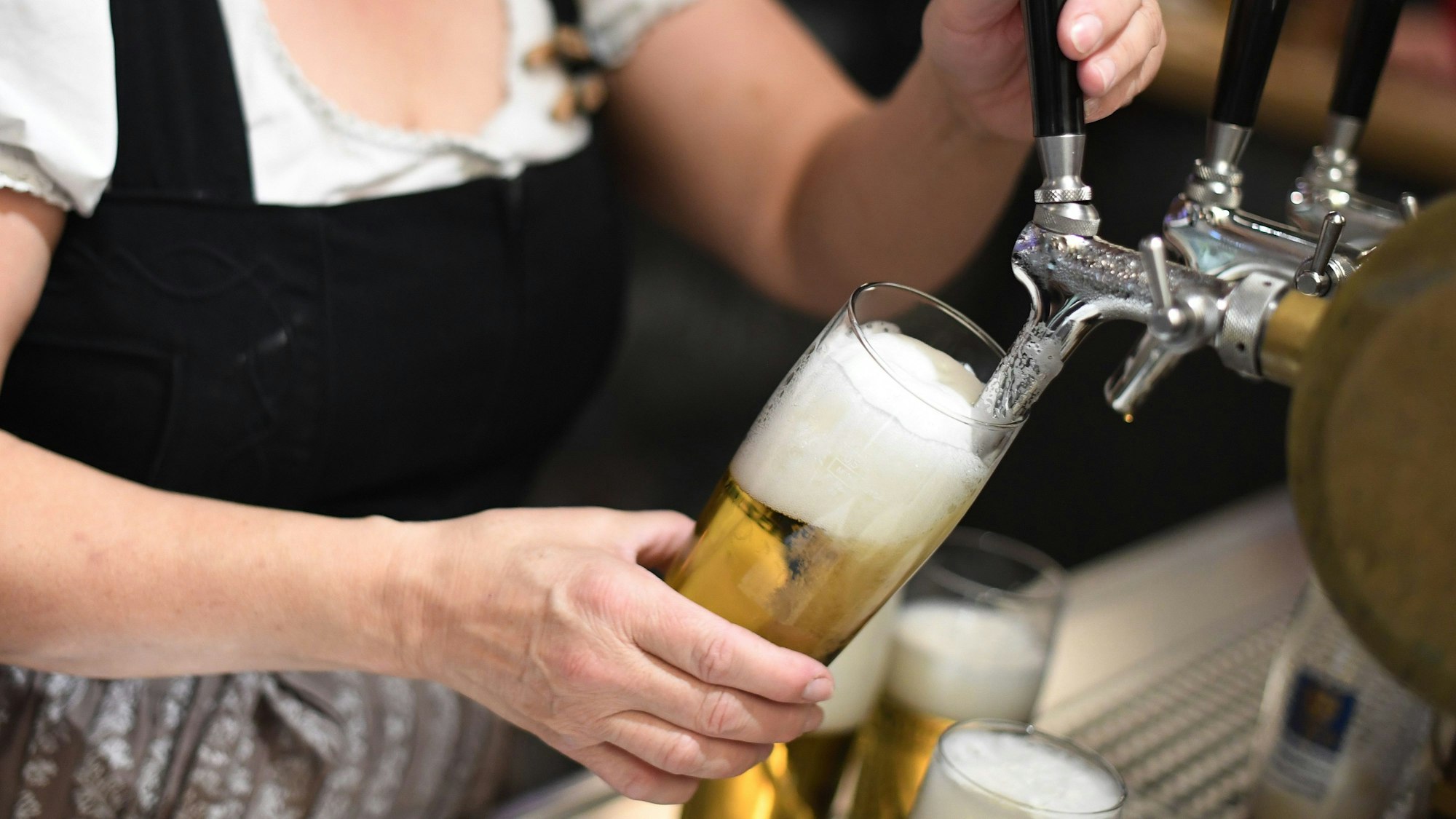 Eine Bedienung zapft Bier in einem Wirtshaus. Die Weltbierproduktion wird im laufenden Jahr voraussichtlich sinken.