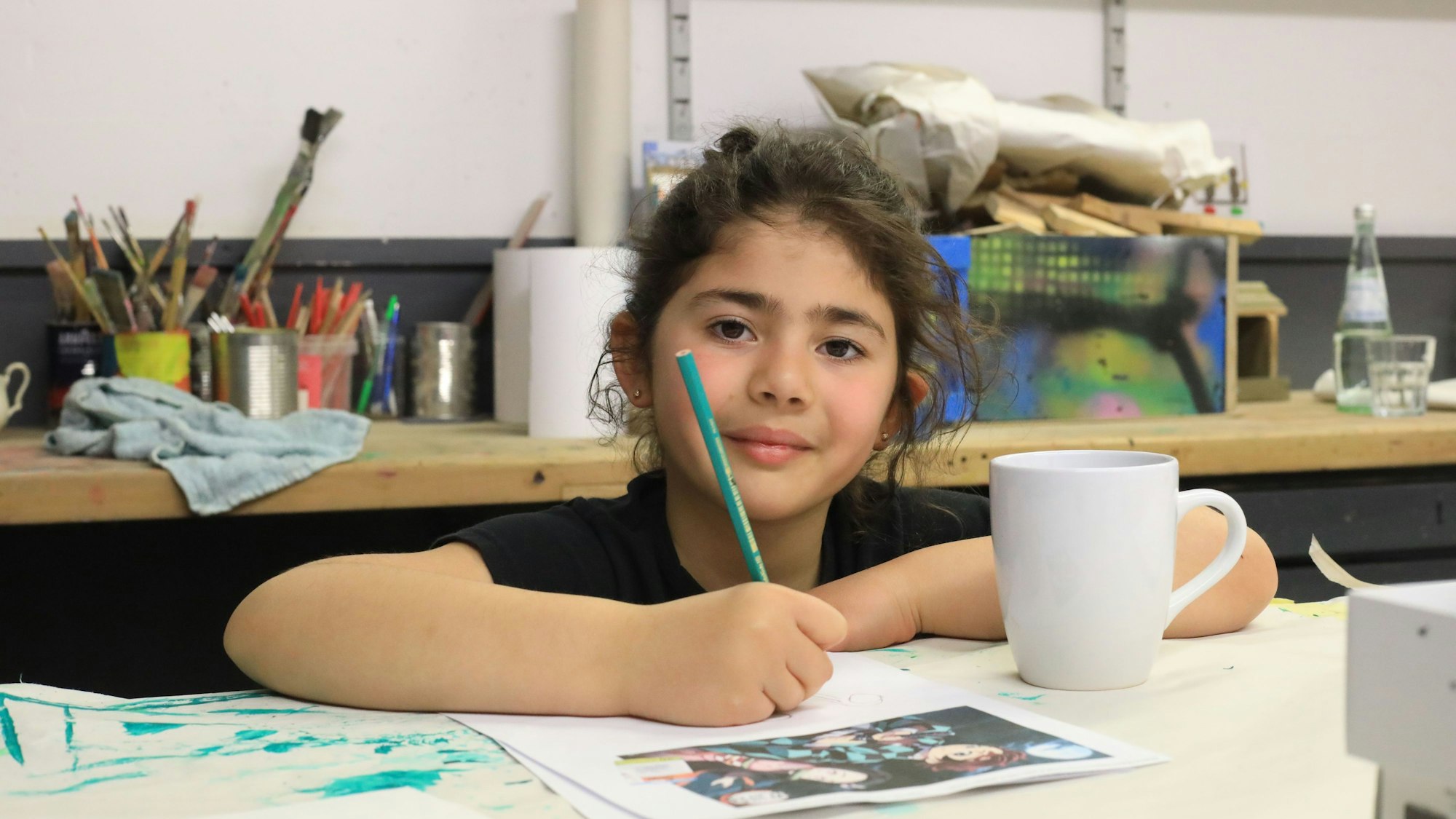 Die neunjährige Ela hat Spaß bei der Arbeit. Ein Motiv ihrer Lieblingsmangaserie will sie auf die Tasse malen.