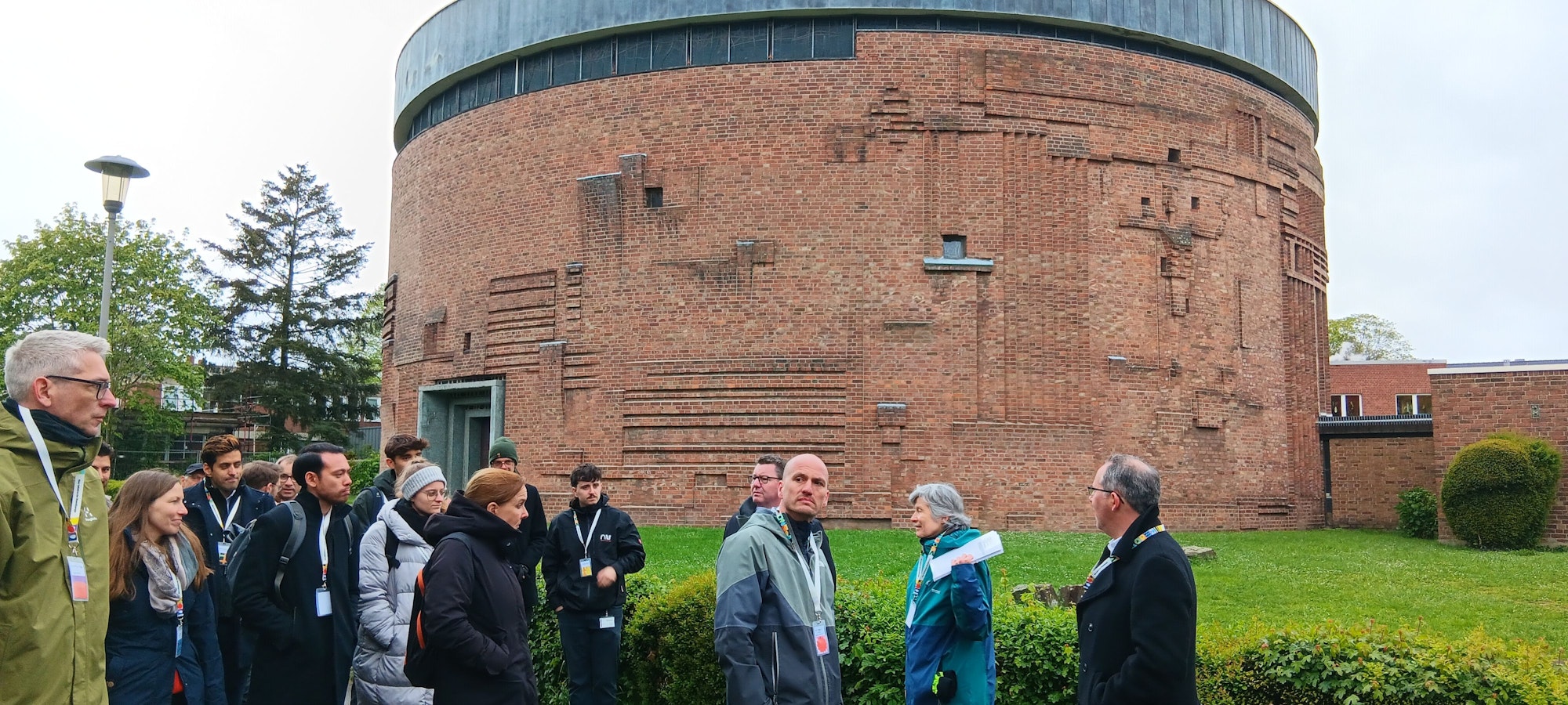 Eine Gruppe von Menschen steht vor einem Rundbau, der als Kirche genutzt wird.