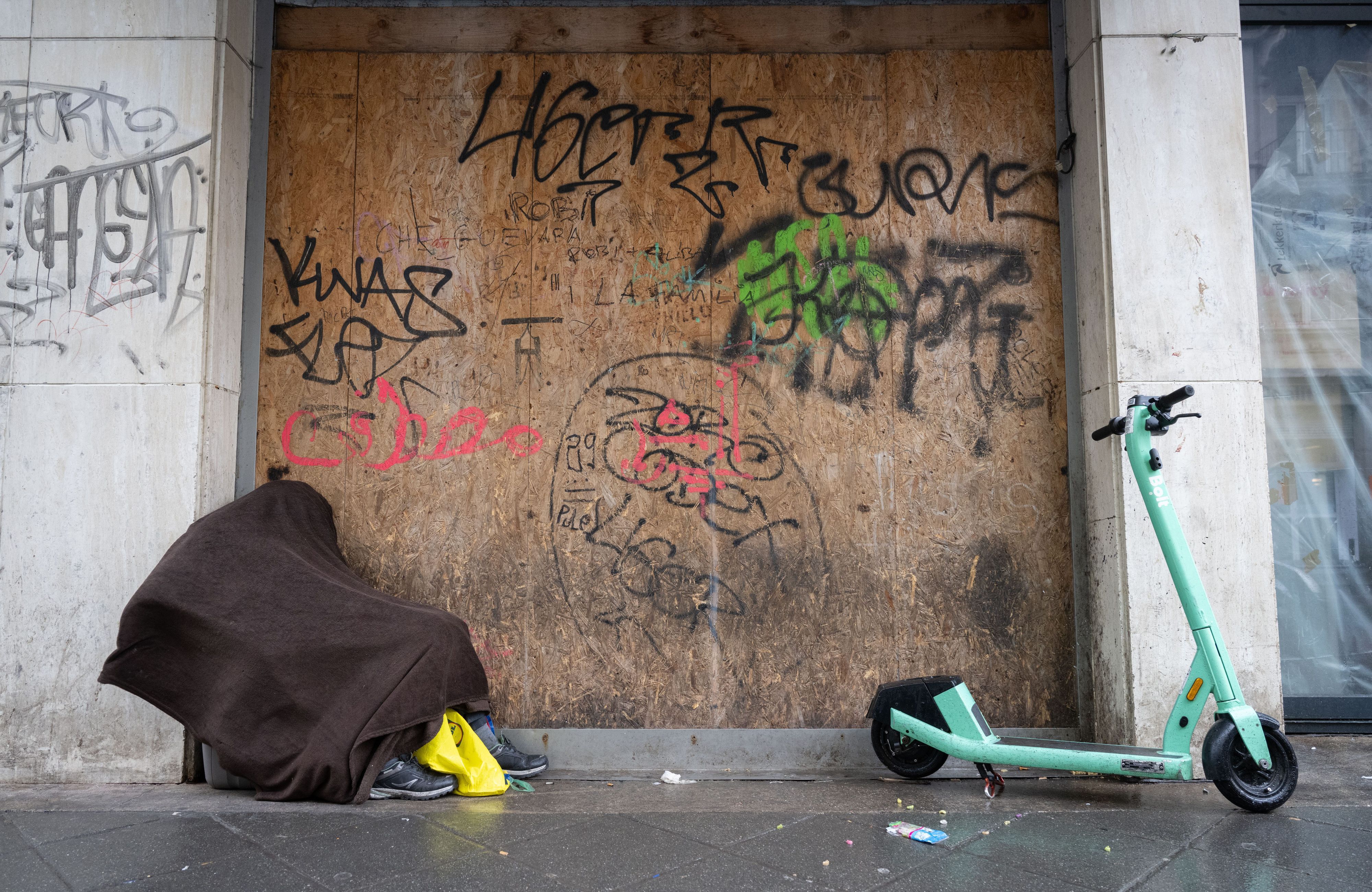 Ein obdachloser Mann sucht in einem Hauseingang Schutz.