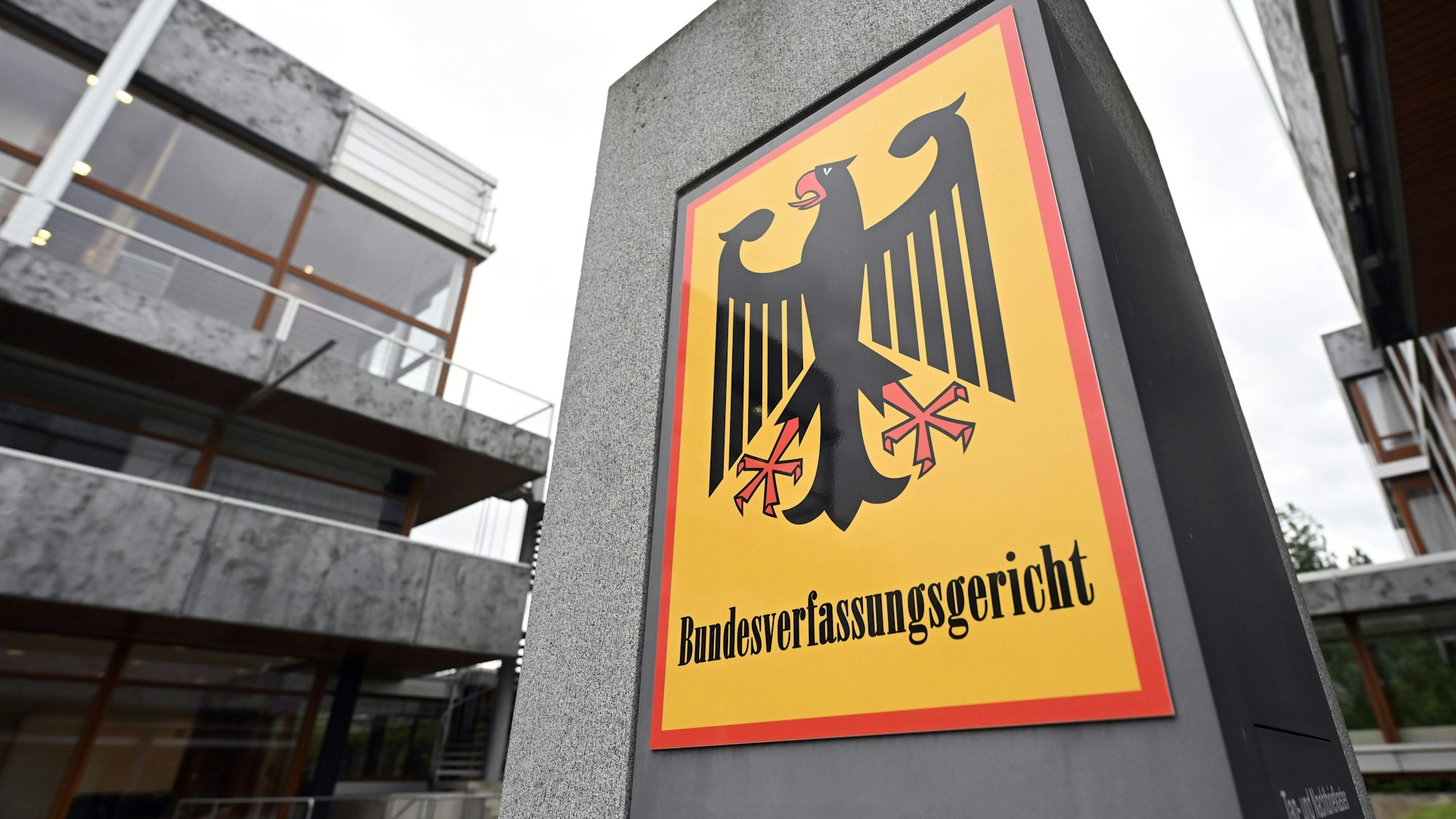 09.04.2024, Baden-Württemberg, Karlsruhe: Ein Hinweisschild mit Bundesadler und dem Schriftzug Bundesverfassungsgericht, aufgenommen vor dem Gericht. Der Erste Senat des Gerichts verkündet (ab 10.00 Uhr) das Urteil in Sachen ·Regelungen zur Vaterschaftsanfechtung·. Derzeit haben biologische Väter kein Recht, Vaterschaften anzufechten, wenn zwischen dem Kind und dem gesetzlichen Vater laut Familiengericht eine sozial-familiäre Beziehung besteht, der Mann also Verantwortung für das Kind trägt. Foto: Uli Deck/dpa +++ dpa-Bildfunk +++