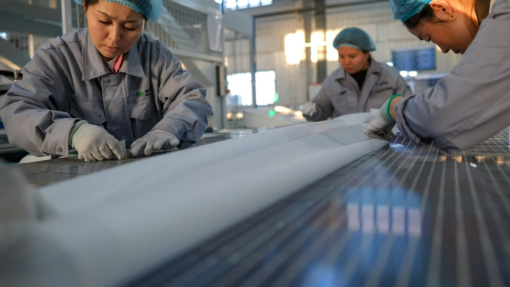China, Mori: Arbeiter fertigen Solarmodule in einer Fabrik in der Autonomen Präfektur Changhi der Hui.