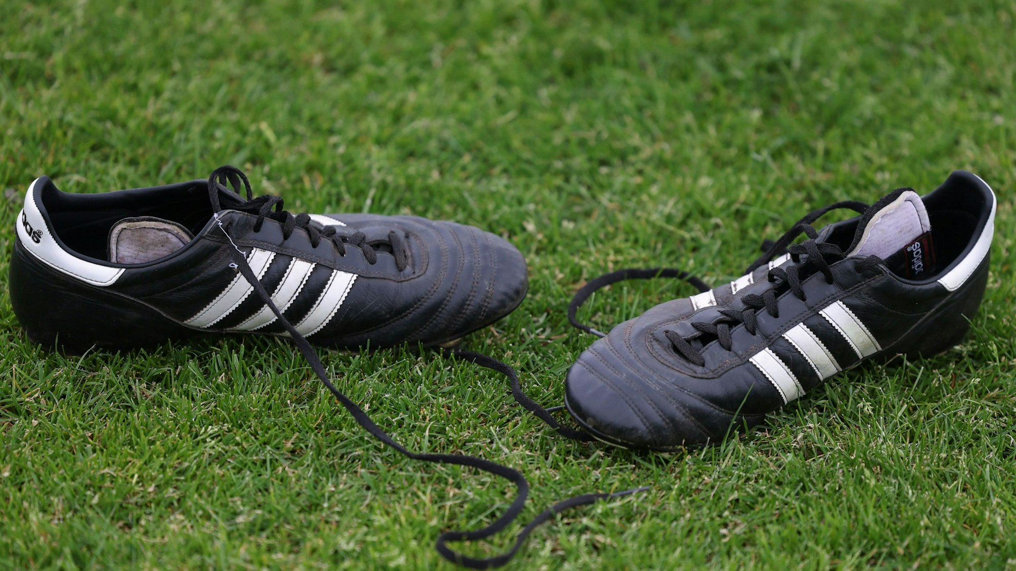 Fußballschuhe liegen am Spielfeldrand. (zu dpa: «Trainer Olivier Caillas wegen Gewaltvorfall am Samstag suspendiert») +++ dpa-Bildfunk +++