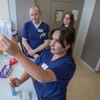 Auch das Vorbereiten von Medikamenten gehört in der Waldbröler Kardiologie zu den Aufgaben der Auszubildenden: Hier macht die Auszubildende Esma Yavuz aus Gummersbach unter Aufsicht von Stationsleiter Daniel Linke eine Infusion fertig. Mitschülerin Zoe Müschenich sieht dabei zu.