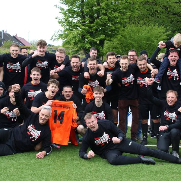 Spieler der SG Keldenich-Scheven jubeln. Zwei halten das Trikot mit der Nr. 14 in die Höhe.