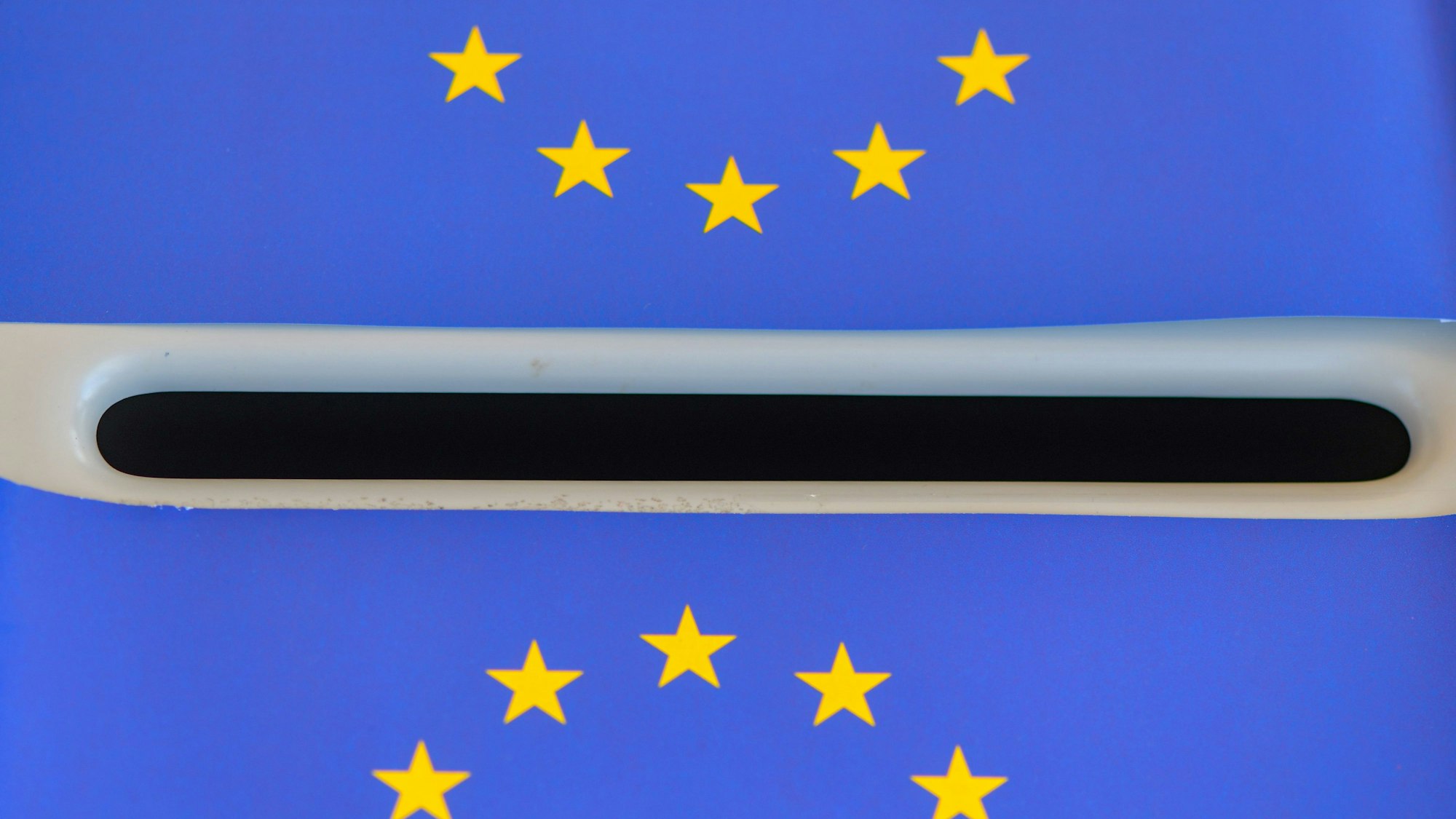 Europa-Fähnchen liegen auf einer Wahlurne.