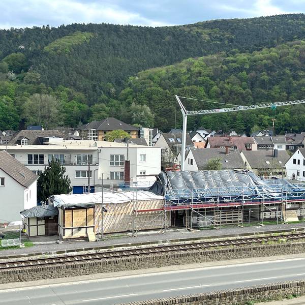 Baustelle zum Abbau des im Stadtteil Walporzheim der Stadt Bad Neuenahr-Ahrweiler gelegenen Bahnhofs. Im Vordergrund verlaufen eine Straße und die Bahnlinie, hinter dem Gebäude steht ein Baukran.