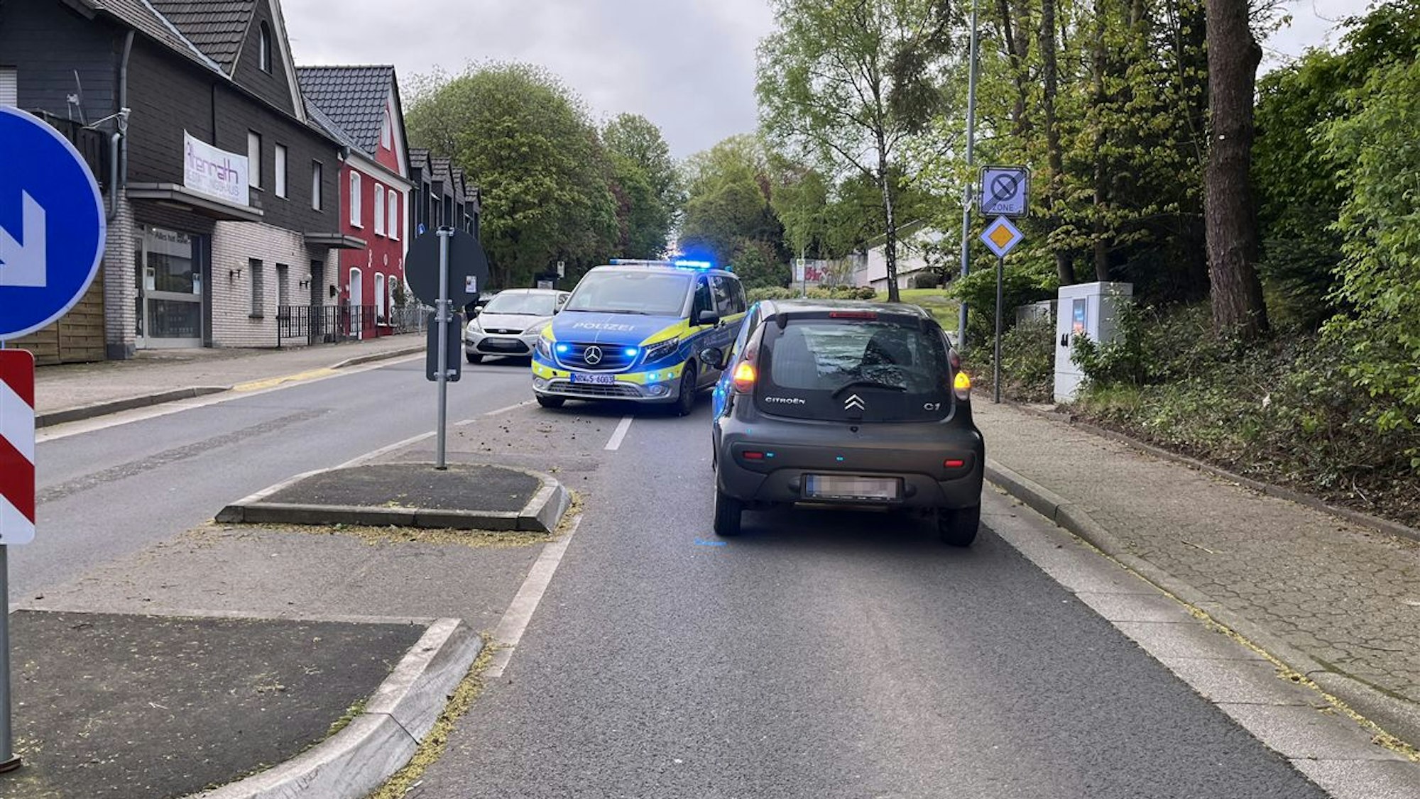 Ein Fußgängerüberweg, ein Auto und ein Polizeifahrzeug.