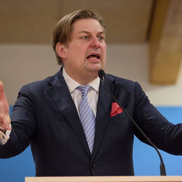 Maximilian Krah, Spitzenkandidat der AfD bei der Europawahl 2024, steht an einem Rednerpult vor einer blauen Leinwand mit dem Parteilogo.