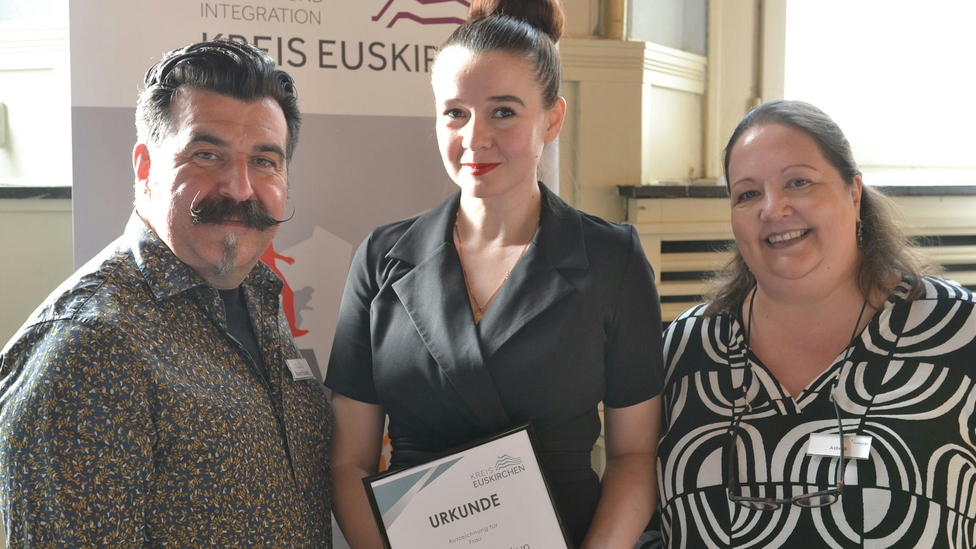 Natalia Skakun hält ihre Urkunde in den Händen, links von ihr steht  Roland Kuhlen, rechts Stefanie Asbeck.