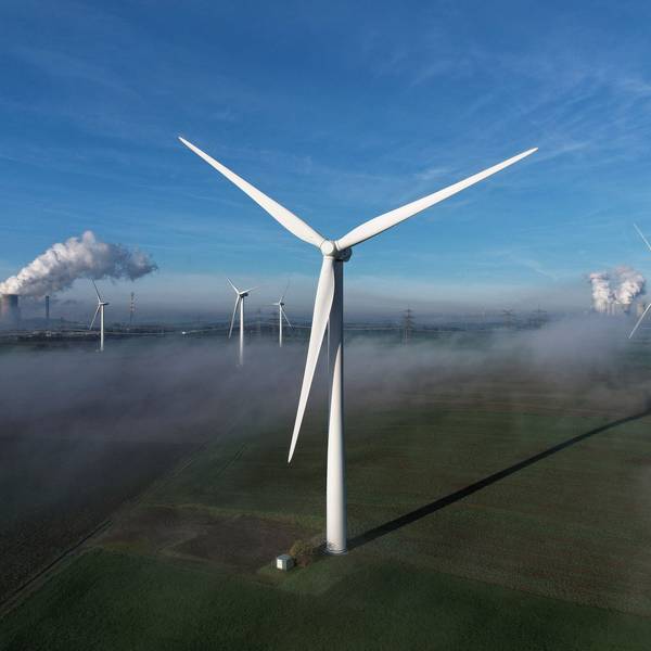 Auf dem Bild sind mehrere Windräder in Bergheim zu sehen, im Hintergrund auch zwei Kohlekraftwerke.