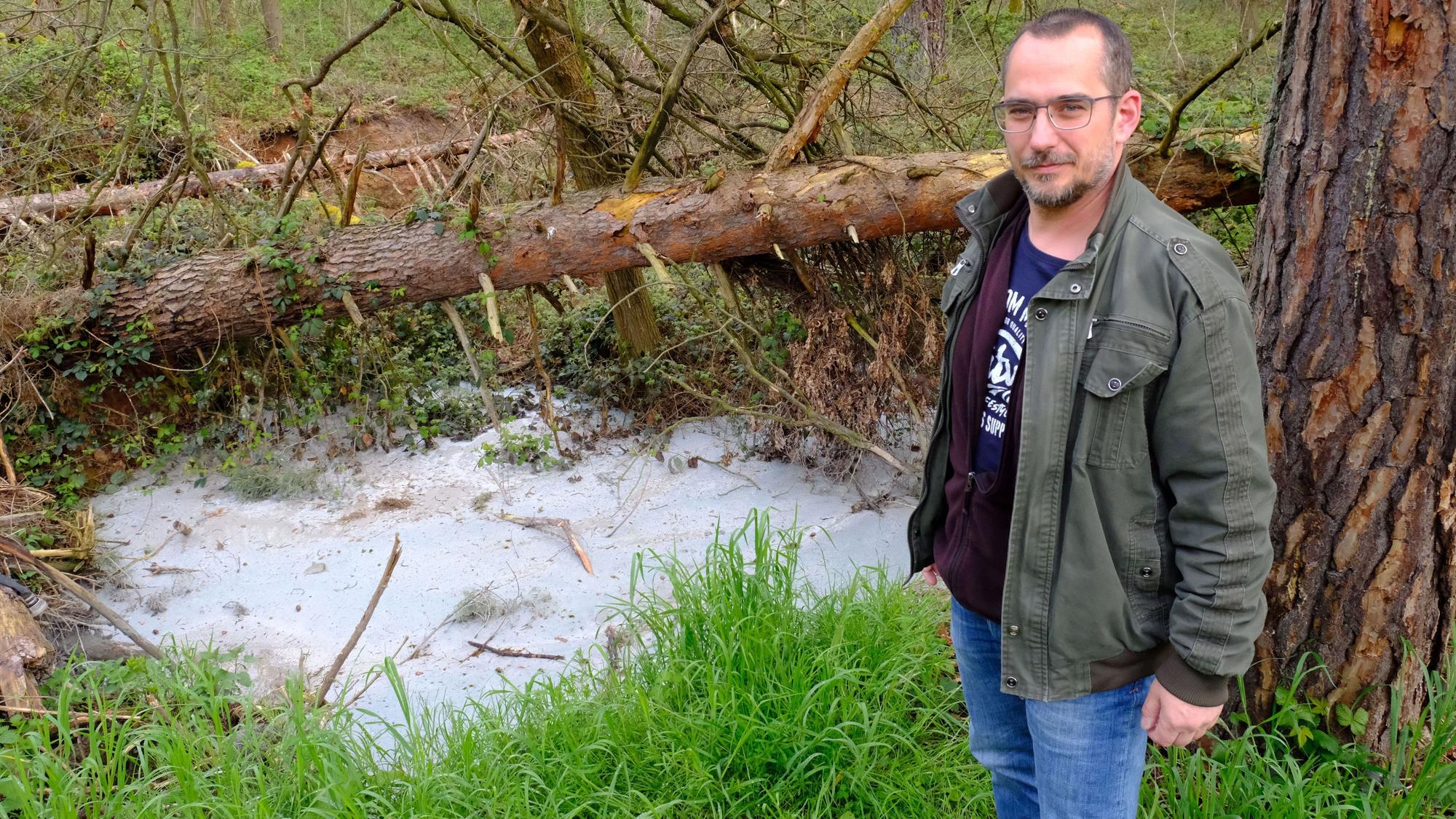 Constantin Hochgürtel steht an einem mit Beton verfüllten Tagebrüche in einem Kiefernwald bei Mechernich.