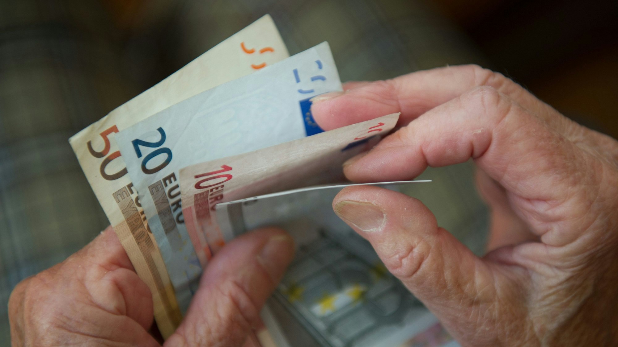 Eine Hand hält Geldscheine.