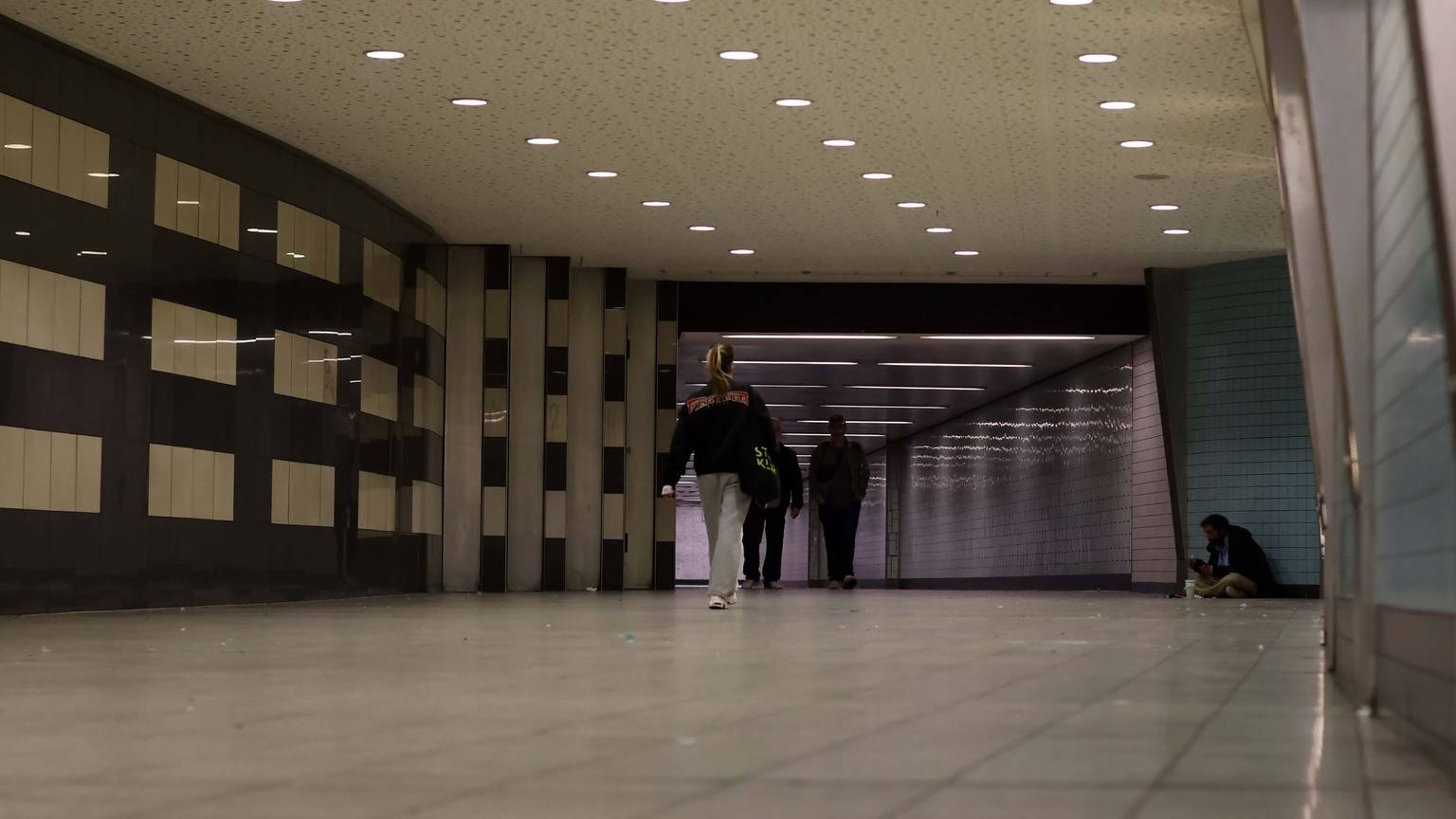Personen gehen durch den Tunnel am Appellhofplatz.