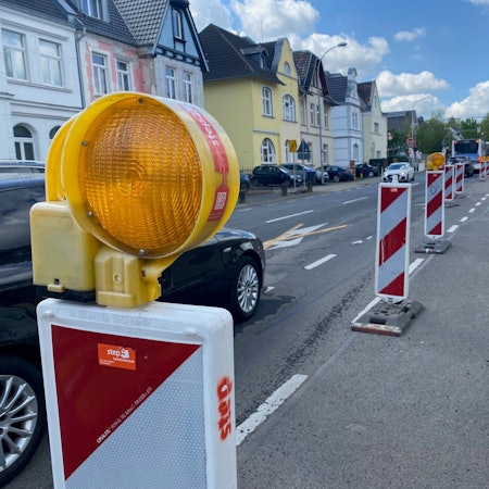 Zu sehen ist die Liblarer Straße, die von Baken eingeengt wird.