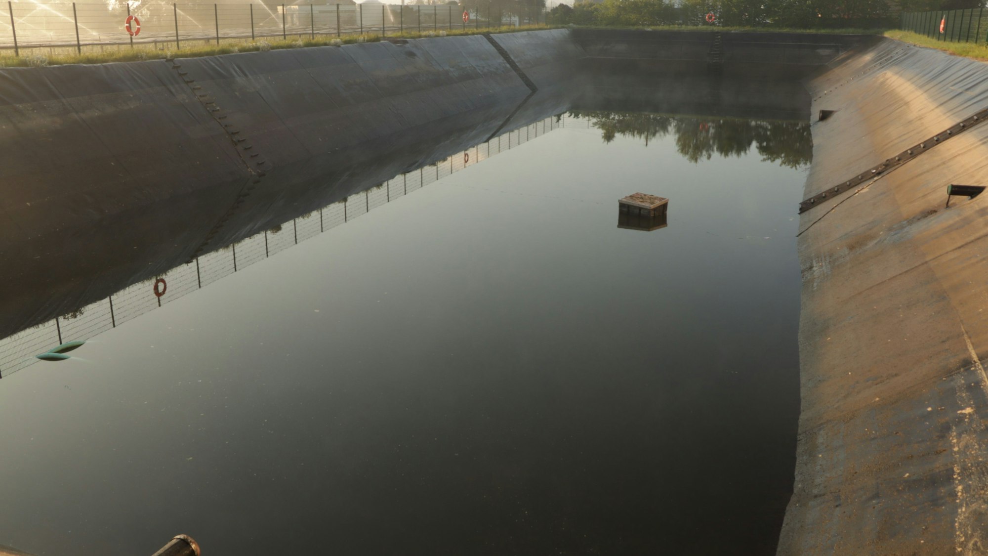 Ein Regenauffangbecken mit wenig Wasser.