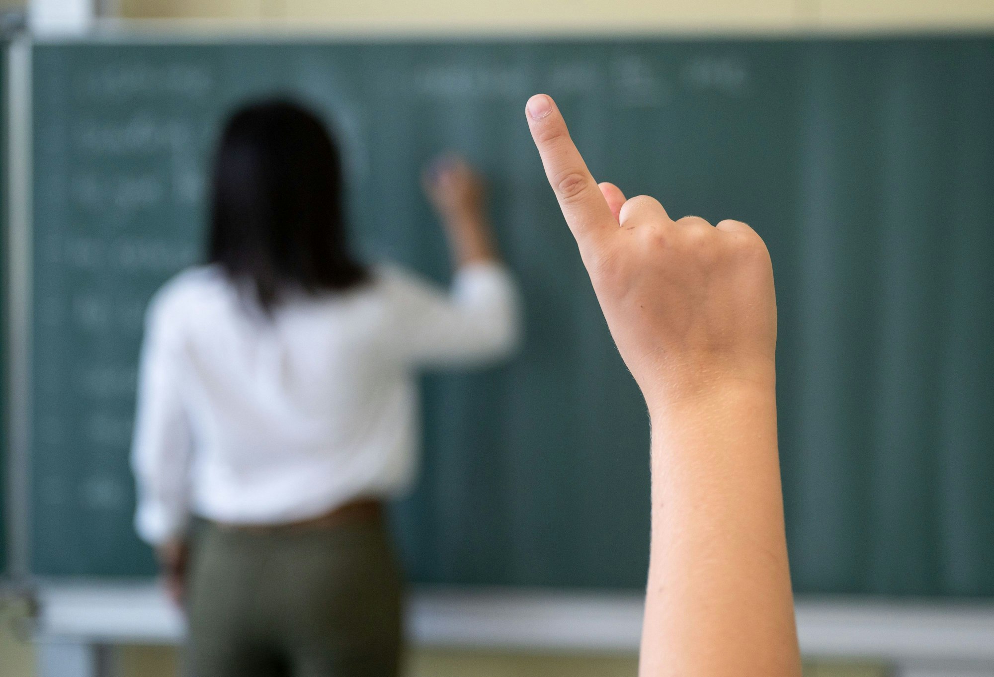 Ein Schüler meldet sich während einer Unterrichtsstunde.