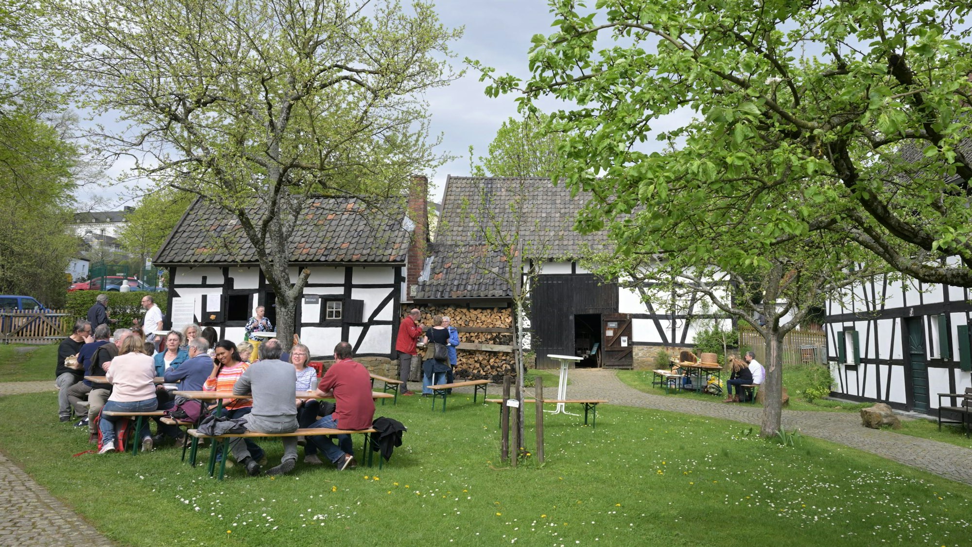 Menschen sitzen auf Bänken vor dem Bergischen Museum.