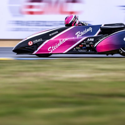 Eine Rennszene mit Fahrer Harry Payne und Beifahrer Kevin Rousseau, der sich aus dem Seitenwagen hängt.