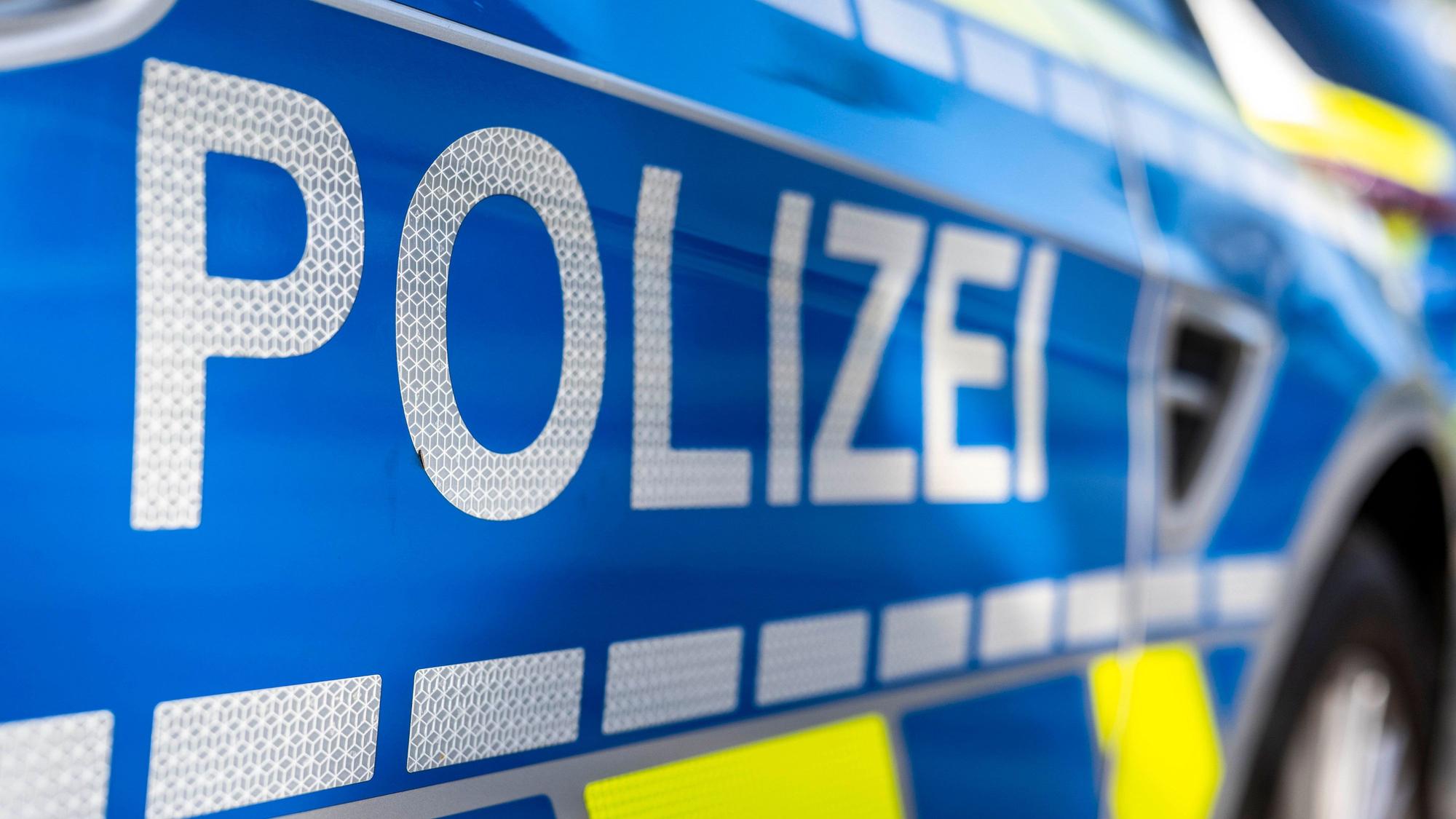 An der Tür von einem Streifenwagen steht der Schriftzug Polizei.