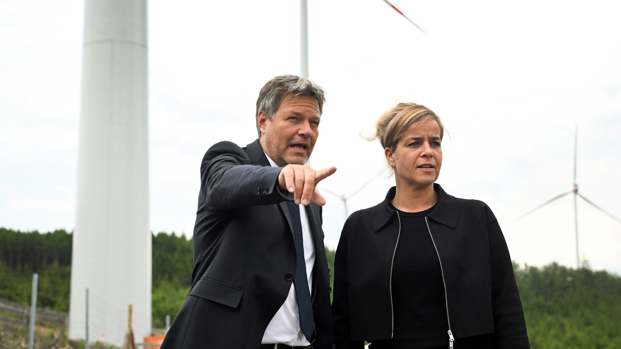 Robert Habeck (l), Bundeswirtschaftsminister, und NRW-Wirtschaftsministerin Mona Neubaur (beide Grüne), stehen vor Windrädern zur Stromerzeugung.