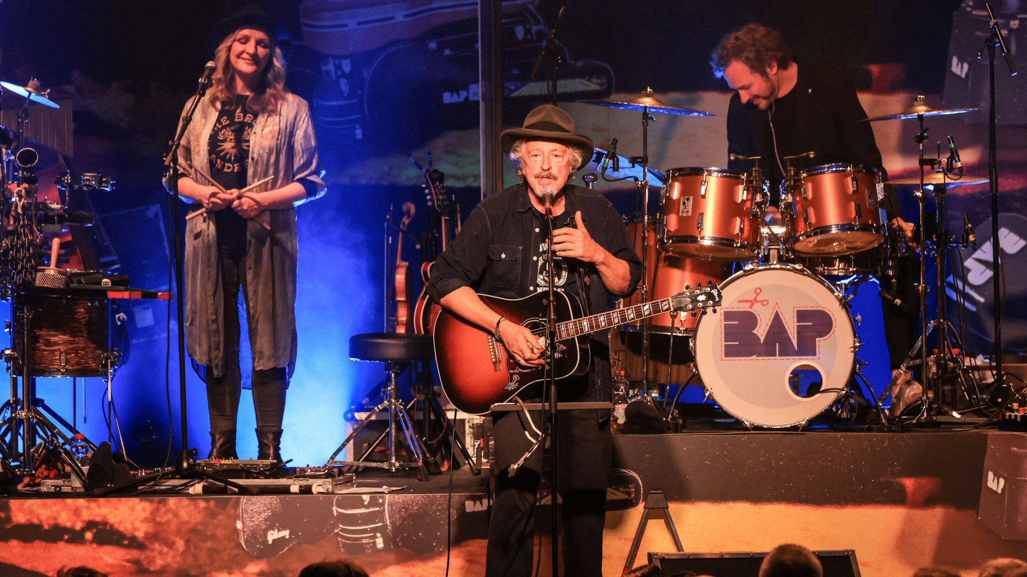 Wolfgang Niedecken steht mit einer Gitarre auf der Bühne.