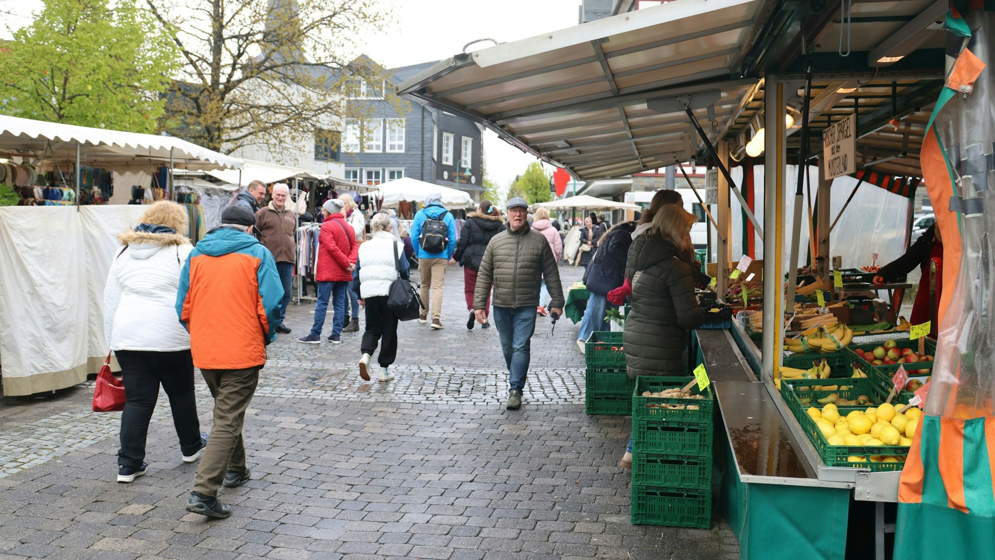 Mehrere Menschen sind auf einem Markt unterwegs.