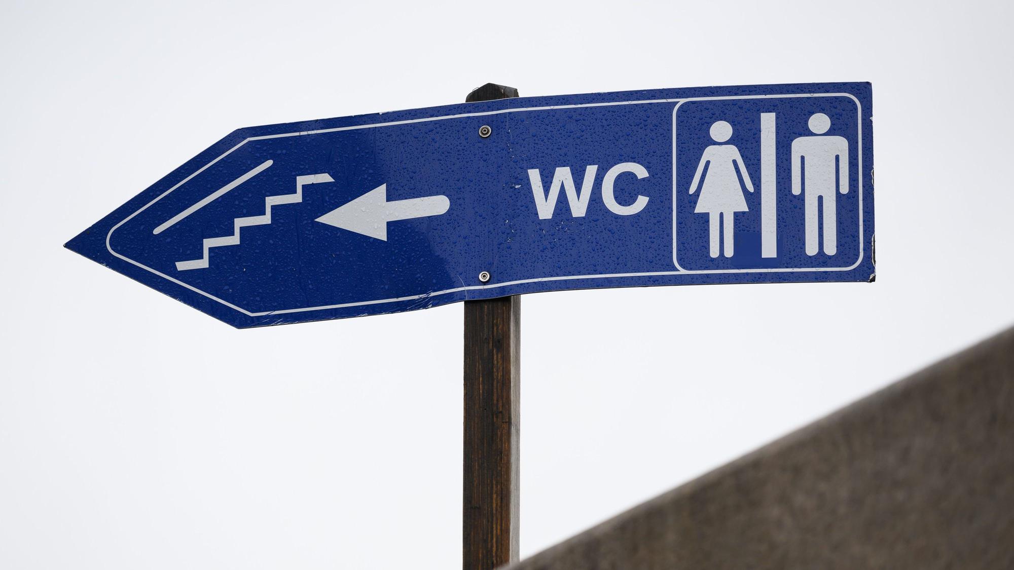 Auf einem Schild werden öffentliche Toiletten ausgewiesen.
